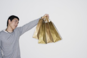 Man indoors holding shopping bags