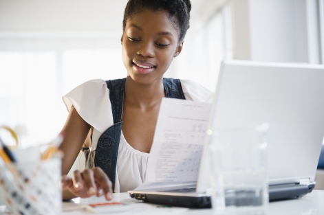 Cropped head-and-shoulders view of a young African-American woman paying bills online